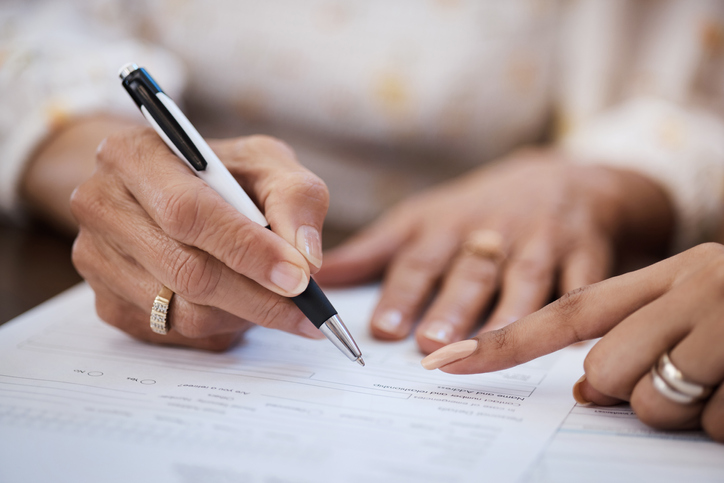 Woman signing estate planning documents with attorney