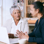 Older woman sitting with estate planning attorney